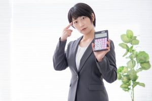 電卓を持つスーツ姿の女性