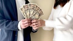 札束を一緒に持つ2人